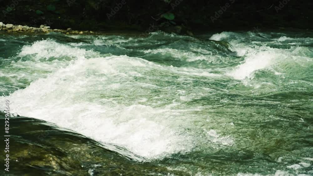 A mountain river with clear water rushing over rocks, creating rapids and white foam. Close-up of the flow of turbulent water. Slow motion A mountain river with clear water rushing over rocks, creating rapids and white foam. Close-up of the flow of turbulent water. Slow motion