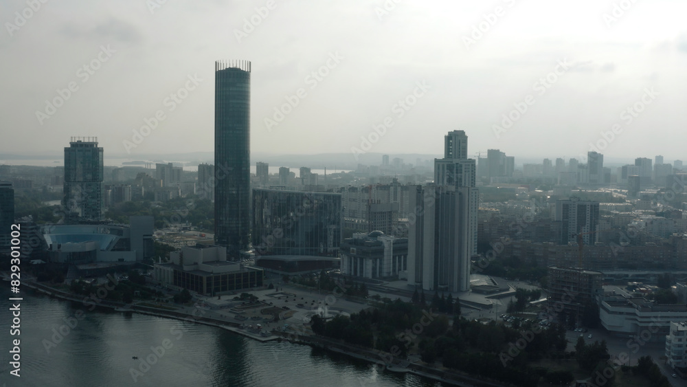 Obraz premium Top view of modern gray city in cloudy weather. Stock footage. Grey cloudy city with river and fog. Cloudy day hanging over modern city