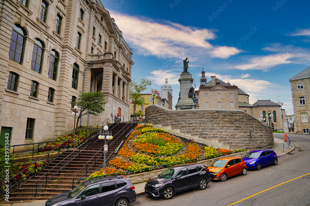 Obraz premium The Saint Francois de Laval Monument with the background of the Basilica Notre Dame as seen from the Montmorency Park in Quebec city, the capital of Quebec province,Canada