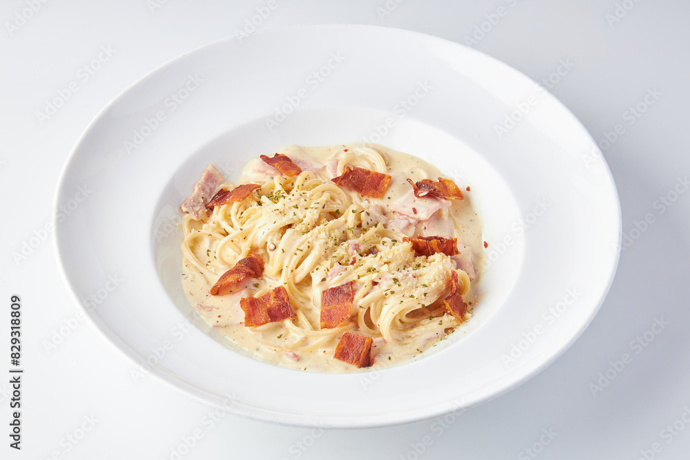 Spaghetti Carbonara topped with ham and bacon served in white plate isolated on white background. italian food. Spaghetti Carbonara topped with ham and bacon served in white plate isolated on white background. italian food.