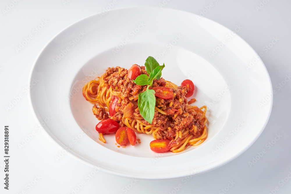 Spaghetti Tomato Sauce with Minced Pork (Bolognese) top with basil leaves served on white plate isolated on white background. Spaghetti Tomato Sauce with Minced Pork (Bolognese) top with basil leaves served on white plate isolated on white background.