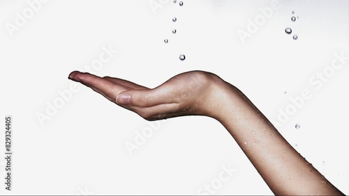 Highspeed shooting: waterdrops fall into an open hand. 4K Resolution photo