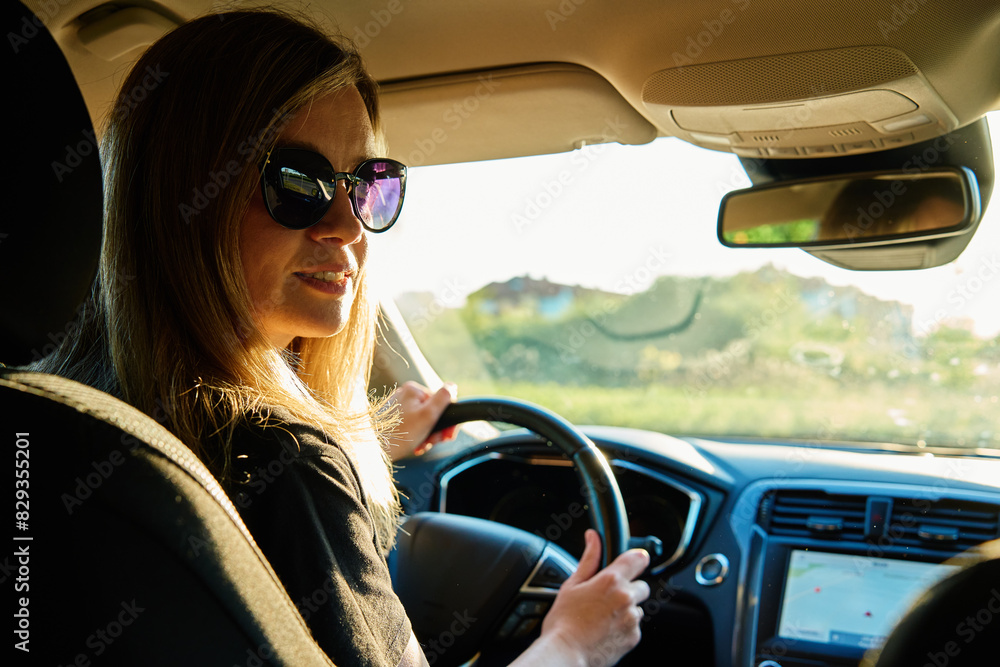Fototapeta premium Woman wearing sunglasses is driving car