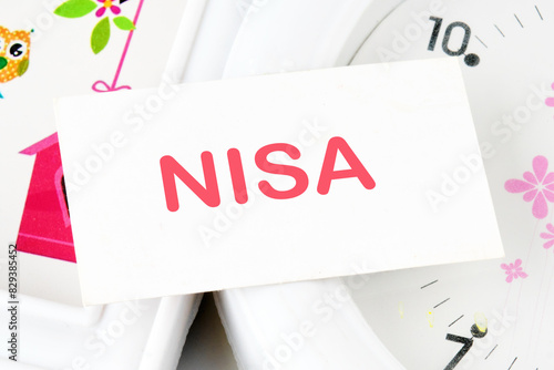 Nippon Individual Savings Account, the word NISA text on the business card on the background of the clock photo