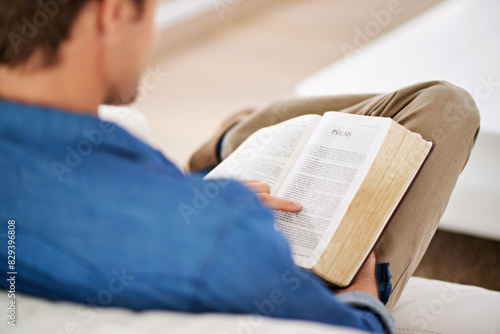Christian, gospel and hands reading bible in living room to worship God, faith or praise Jesus Christ in home. Spiritual, holy book and person studying scripture story on sofa for learning religion photo