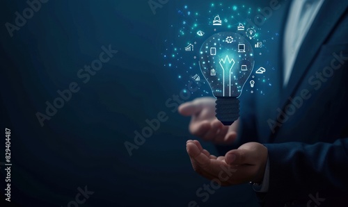 Businessman holding a light bulb with innovation icons inside. Concept of creativity and business ideas.