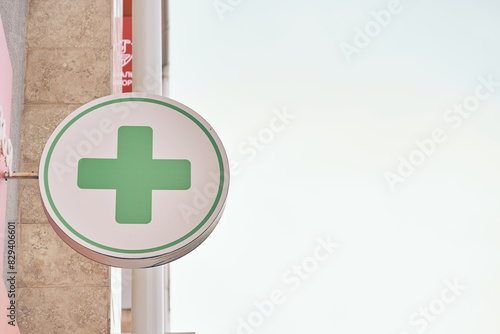Close-up of a green pharmacy sign near a pharmacy store, on the corner of a building with a copy space. High quality photo