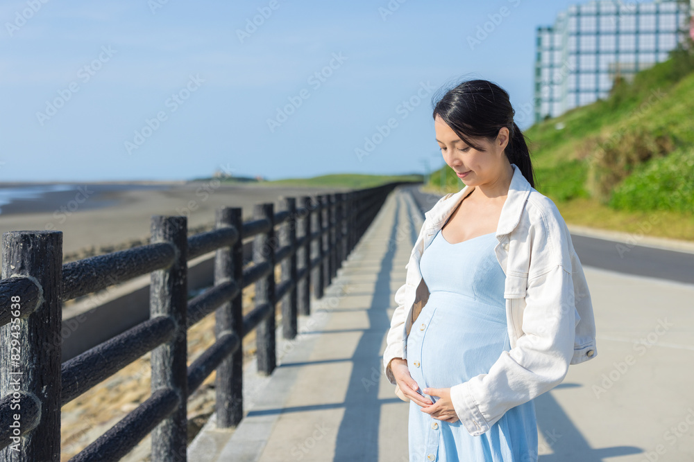 Pregnant woman look at her belly at outdoor Pregnant woman look at her belly at outdoor