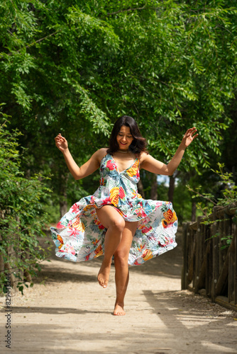 Latin woman wearing a flower dress in nature. happy lifestyle