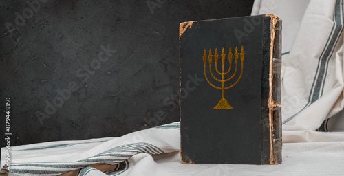 Old book Talmud, Hebrew Rabbinic Judaism, Jewish religious law. Torah, Hebrew Bible. Menorah on a dark cover. Holy Scripture containing the word of God. Antique edition, vintage worn paper photo