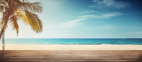 Summer beach scene with a palm tree and a wooden platform providing an inviting copy space image
