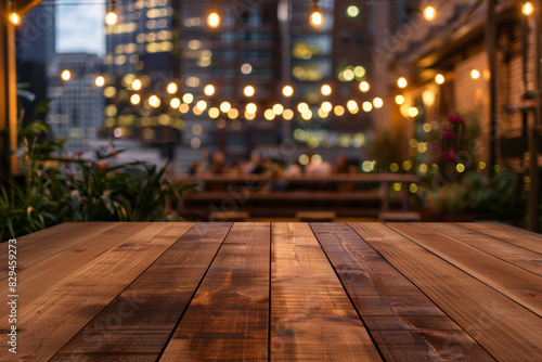 A wooden bar top in the foreground with a blurred background of an urban rooftop bar. The background includes stylish seating, plants, string lights, a panoramic city view.