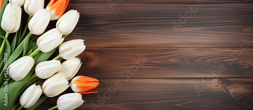 The wooden background showcases a vibrant display of white and orange tulips leaving ample copy space in the image #829464808