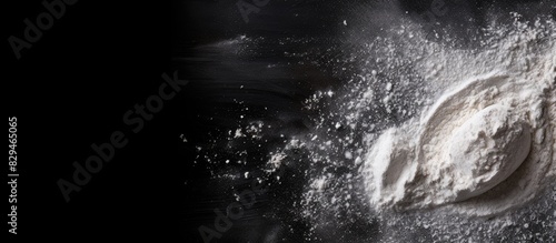 Panel kuchenny z motywem A top view of a black background with sprinkled flour creating a baking ambiance There is ample copy space in the image