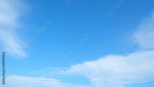 A clear blue sky with a few scattered, wispy white clouds. The sky transitions smoothly from a deeper blue at the top to a lighter blue near the horizon, creating a serene and expansive atmosphere. 