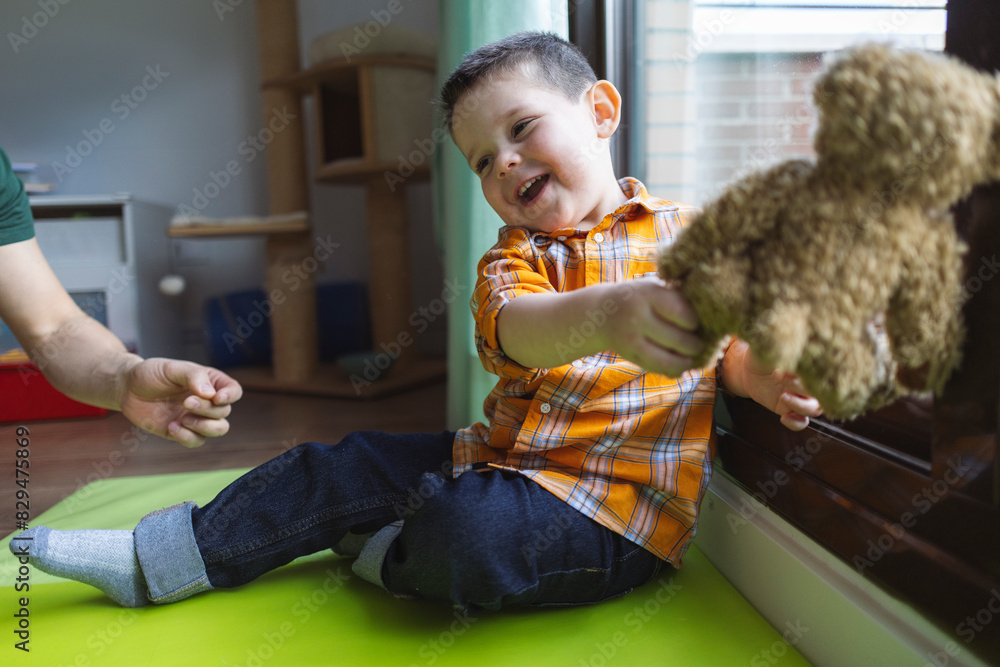 Hand of man near boy playing with stuffed teddy bear at home Hand of man near boy playing with stuffed teddy bear at home