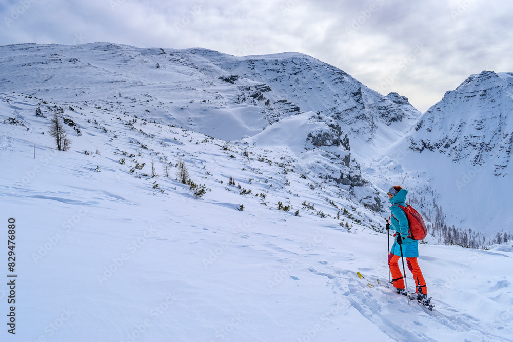 Woman back country skiing with backpack towards Warscheneck, Totes Gebirge, Upper Austria, Austria Woman back country skiing with backpack towards Warscheneck, Totes Gebirge, Upper Austria, Austria