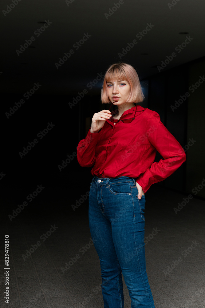 Blond young woman standing in underground parking lot Blond young woman standing in underground parking lot