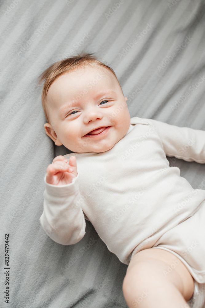 Smiling baby boy lying on gray blanket Smiling baby boy lying on gray blanket