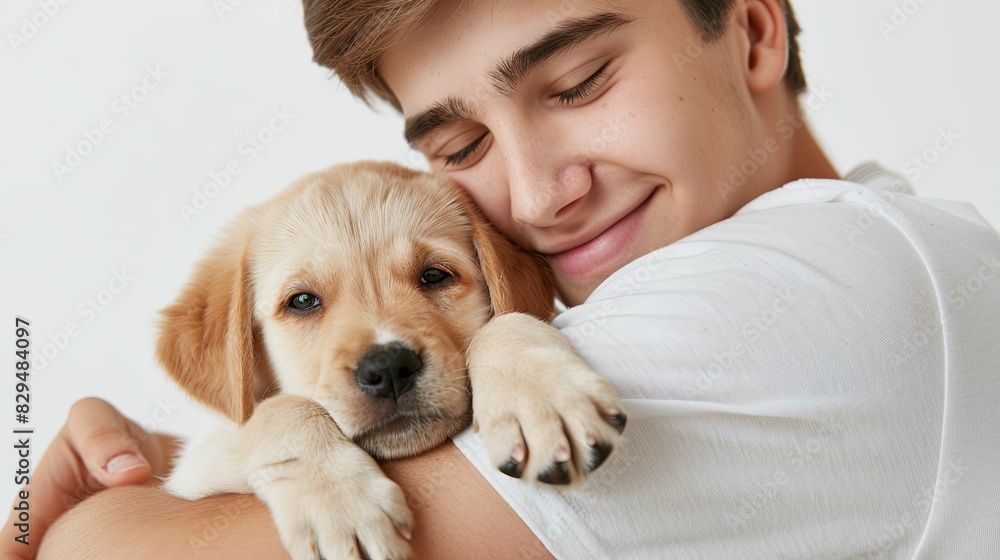 Attractive man hugging a young, pretty puppy. Close-up, white isolated background. Studio photo. Concept of care, education, obedience training, raising of pets