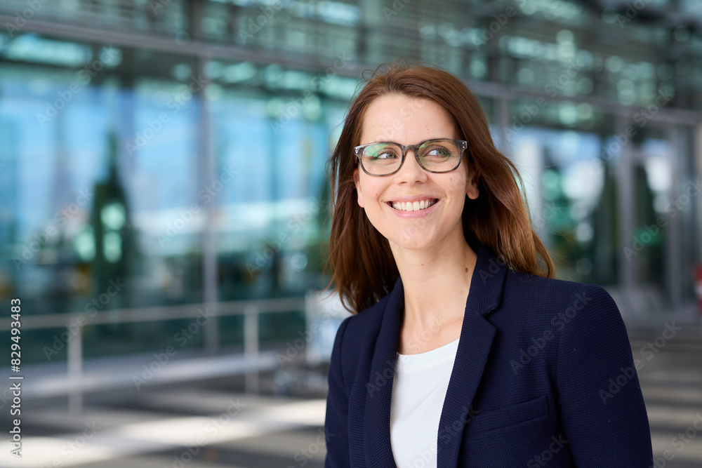 Smiling businesswoman wearing eyeglasses at airport Smiling businesswoman wearing eyeglasses at airport
