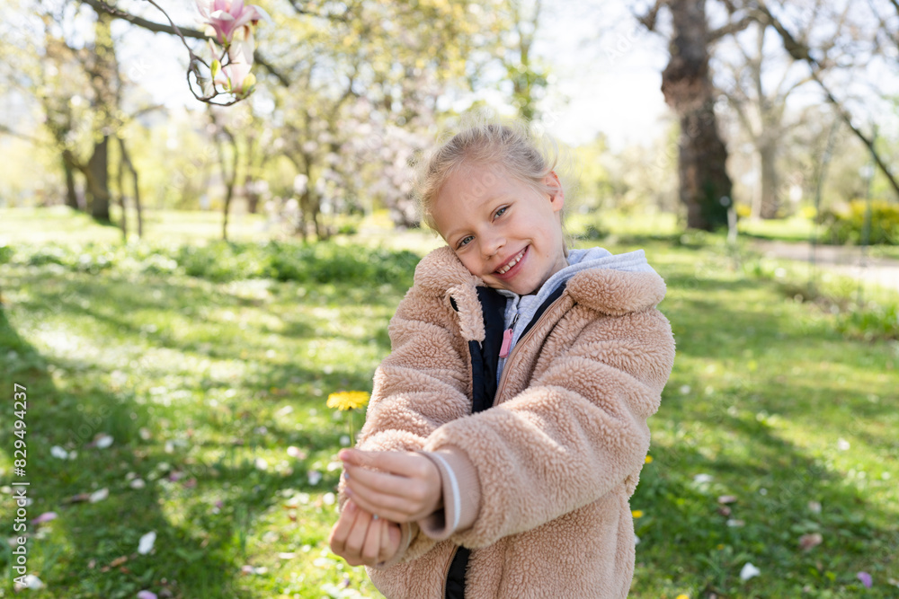 Cheerful girl holding spring flower at park Cheerful girl holding spring flower at park