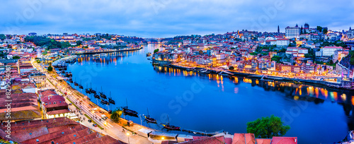 Night cityscape panorama skyline of Porto old town, Luis I Bridge and river Douro banks with reflections.