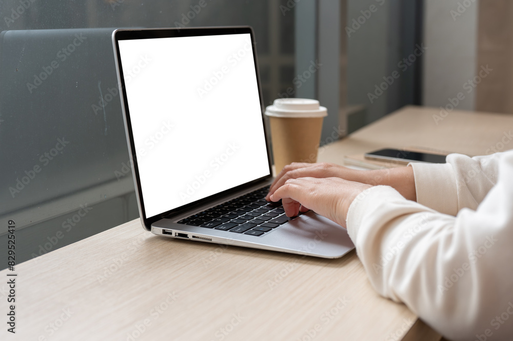A close-up image of a woman working remotely at a coffee shop, working on her laptop computer. A close-up image of a woman working remotely at a coffee shop, working on her laptop computer.