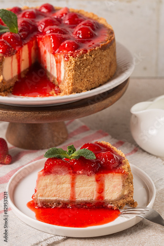 Slice of Classic baked Cheesecake  with a strawberry topping sauce. Homemade dessert. Vertical image.