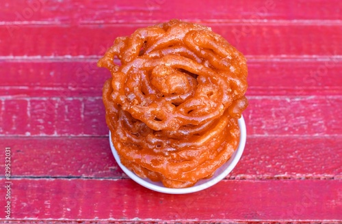 Jalebi or Jilapi in Plate Isolated on Red Wooden Background with Copy Space, Also Known as Zalabia or Mushabak
