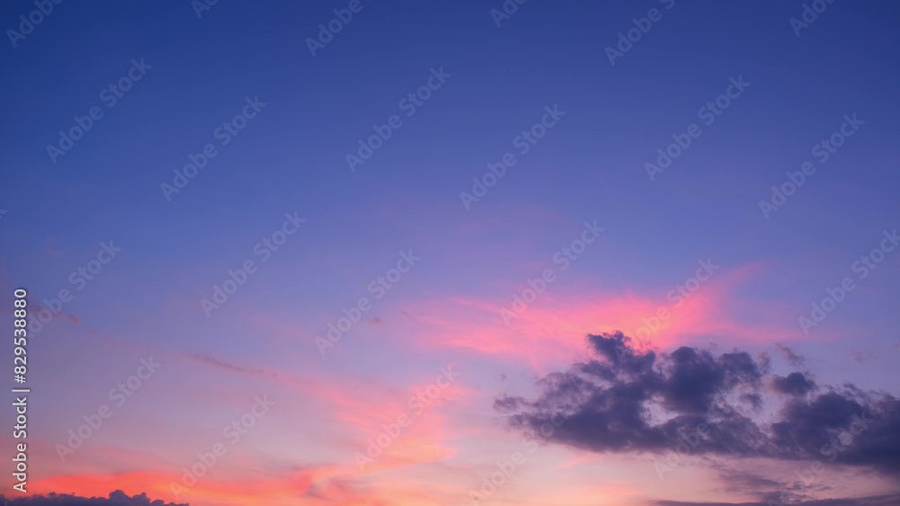 Obraz premium A beautiful sunset with the sky bathed in vibrant shades of pink and purple. Dark clouds add contrast, enhancing the serene and tranquil ambiance of the evening sky. Sunset sky background. 
