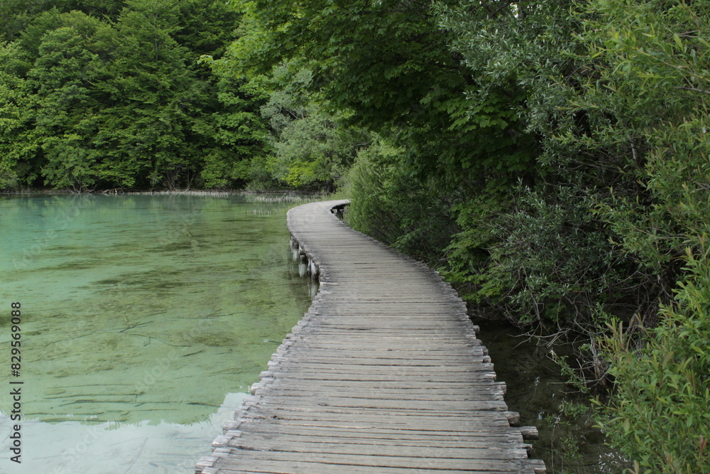 A wooden bridge that stretches along a transparent lake in Croatia. Plitvice lakes. A wooden bridge that stretches along a transparent lake in Croatia. Plitvice lakes.