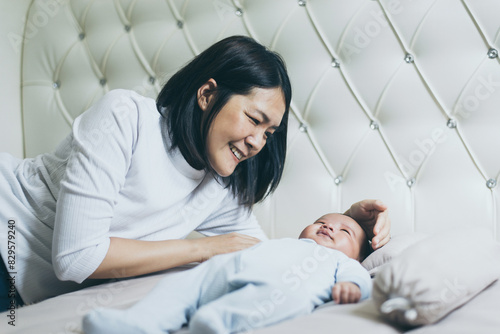 Adorable asian baby boy relaxing with mom on bed,Newborn child
