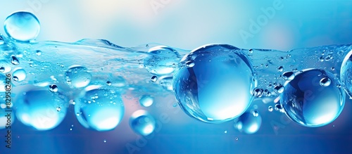 Blue bubbles gracefully floating in a beautiful abstract background with copy space image