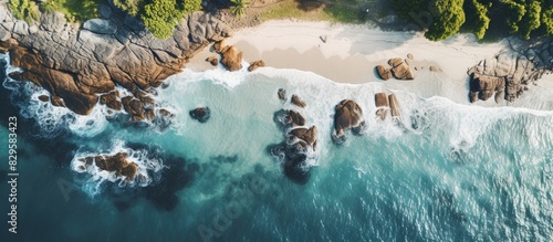 A drone captured an aerial photo of a beach with rocks and vegetation on a cloudy day revealing a panoramic view of the sea coast with copy space image