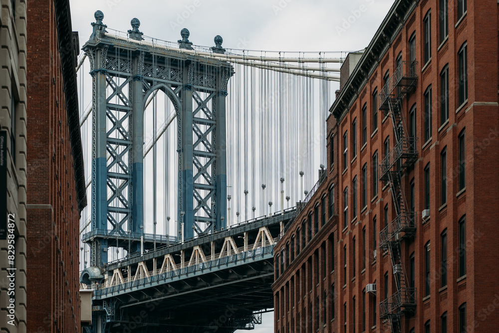 Naklejka premium Scenic view of Manhattan Bridge between buildings in New York City