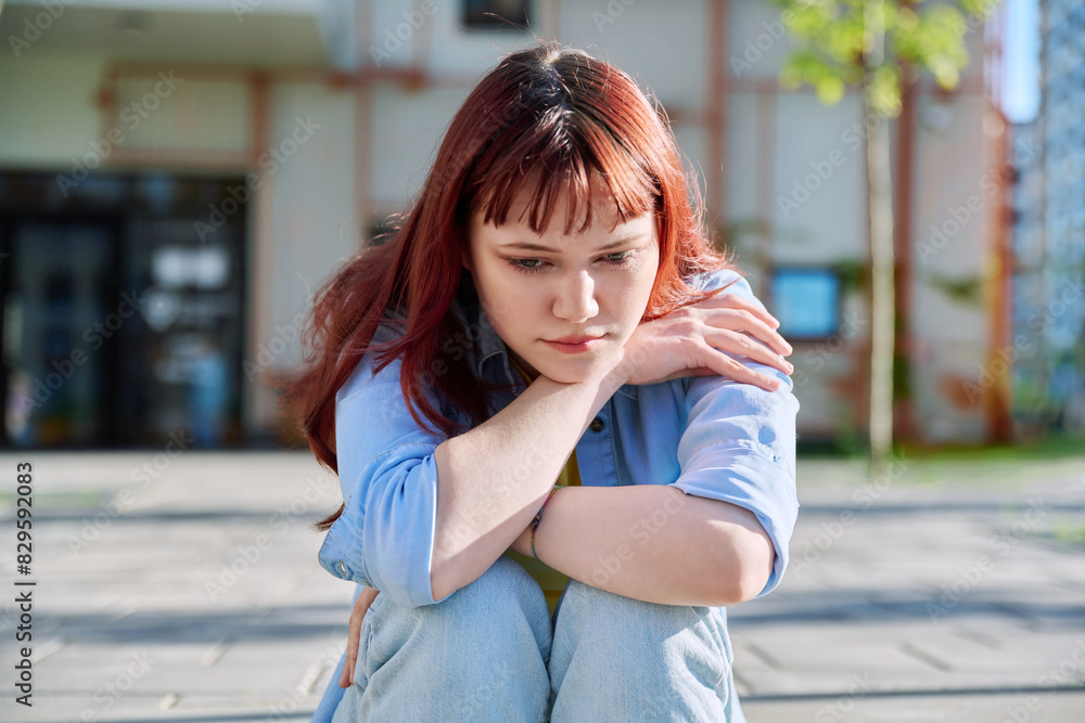 Upset sad unhappy young female sitting outdoor on steps Upset sad unhappy young female sitting outdoor on steps