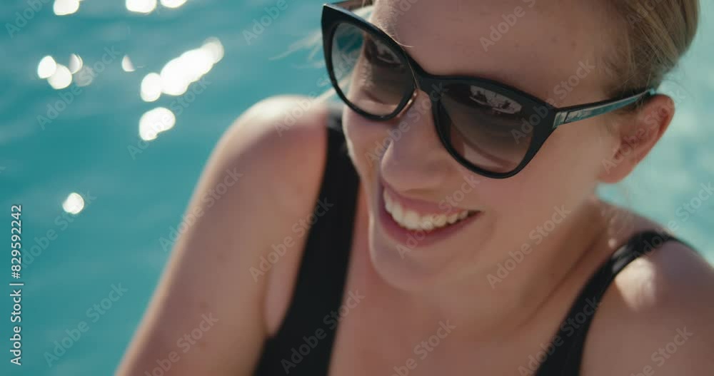 Woman smiles enjoys swimming pool summer vacation sunglasses close up Woman smiles enjoys swimming pool summer vacation sunglasses close up