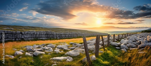 Picturesque Burren region with unique rock formations traditional stone fences under a blue cloudy sky with a sun flare creates an enchanting copy space image photo