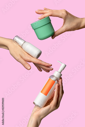 Woman`s hands showing set of cream products. Cosmetic product branding mockup. Daily skincare and body care routine. Female hand holding  cosmetic product mockup on a light pink background. Close up.