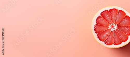 Minimal concept of sliced grapefruit on a soft pastel pink background with a copy space image photo