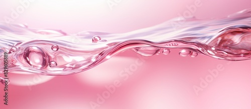 Clear pink water texture with ripples bubbles and waves in sunlight for a summer themed banner with copy space image for cosmetics like moisturizers and toners photo