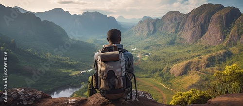 An African male tourist with a backpack is seated while admiring the scenery creating a captivating copy space image