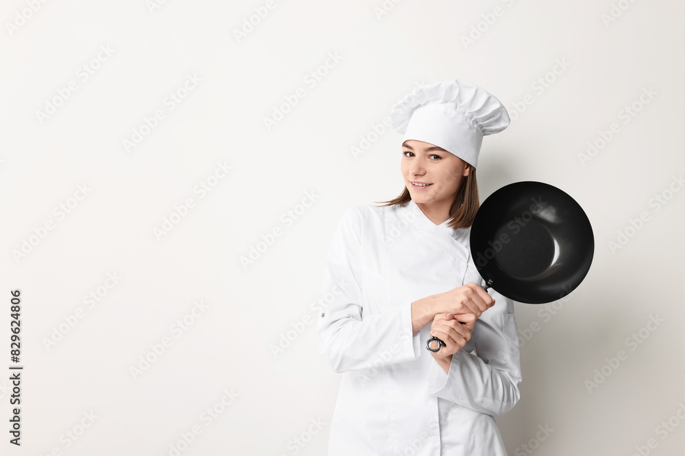 Professional chef with frying pan on light background. Space for text Professional chef with frying pan on light background. Space for text