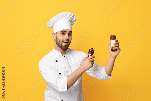 Professional chef with shakers on yellow background