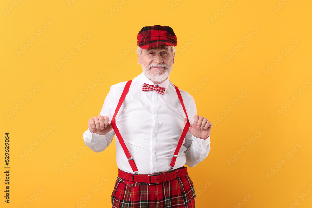 Portrait of grandpa with stylish hat and bowtie on yellow background Portrait of grandpa with stylish hat and bowtie on yellow background