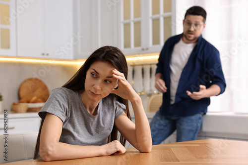 Stressed wife trying to ignore her angry husband in kitchen, selective focus. Relationship problems