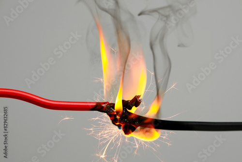 Fotografía Electrical wire burning and sparking on light background, closeup
