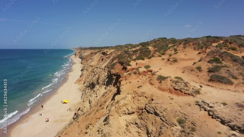 Aerial video along the coastline on a sunny day, waves crashing on the beach, Israel Aerial video along the coastline on a sunny day, waves crashing on the beach, Israel