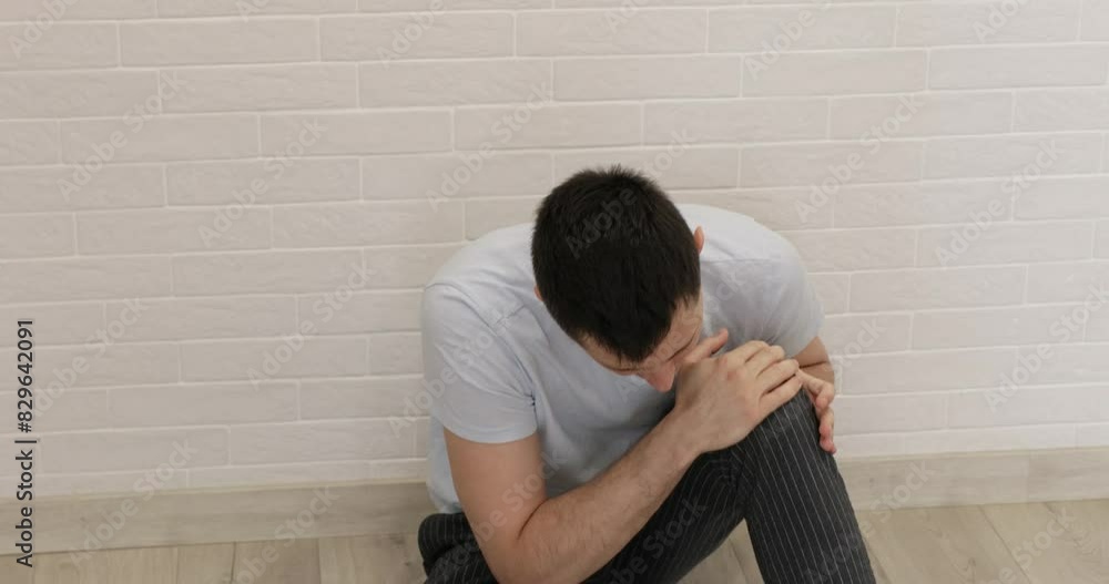 Caucasian man rubs his knee as it is aching.